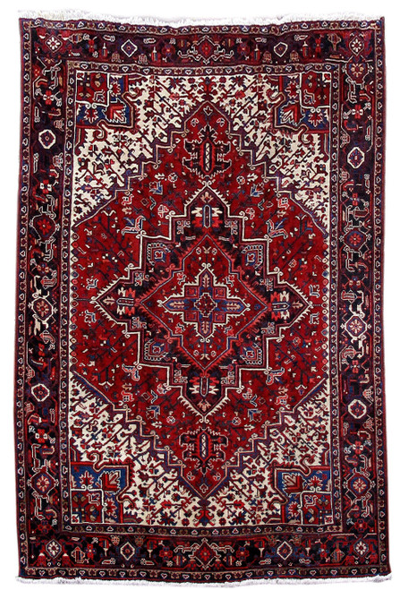 Red Persian Heriz rug with ivory corner spandrels and stepped navy medallion in 7x10 size