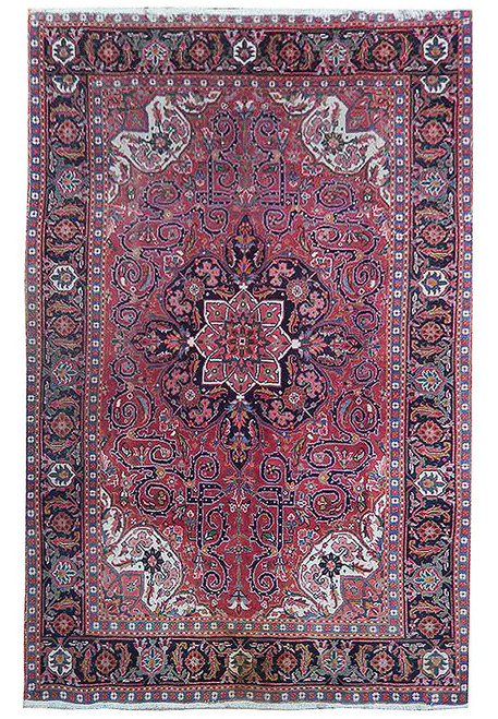 Red Persian Heriz rug with navy star medallion, ivory corner spandrels and scrolling vine field