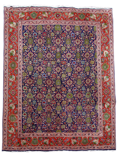 Navy blue all-over floral field framed by a wide red Tabriz border, full overhead view