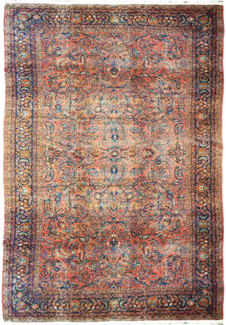 Full overhead view of antique coral Persian Sarouk rug with navy floral border and ivory fringe
