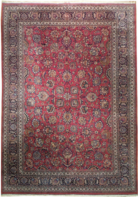 Full view of red Persian Mashad rug with all over floral field and navy border