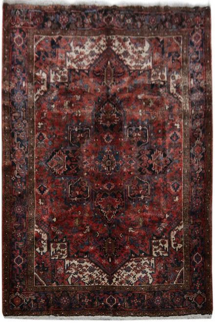 Salmon red Persian Heriz rug with navy stepped medallion and ivory corner spandrels, full overhead view