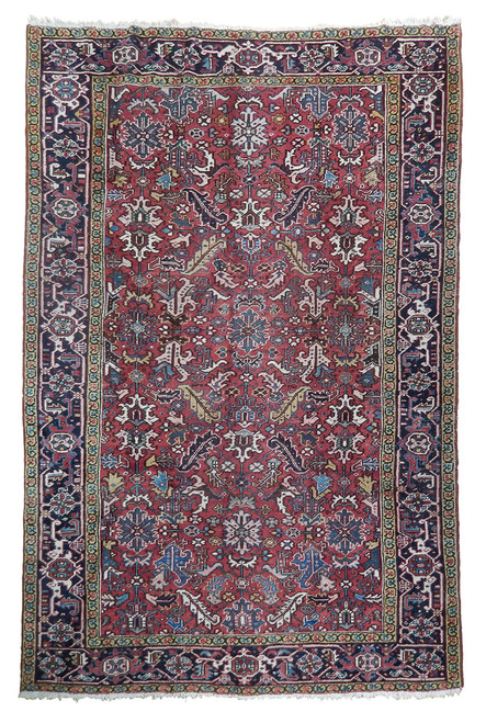 Full overhead view of 7'7" x 10'10" Persian Heriz rug with red field and navy border