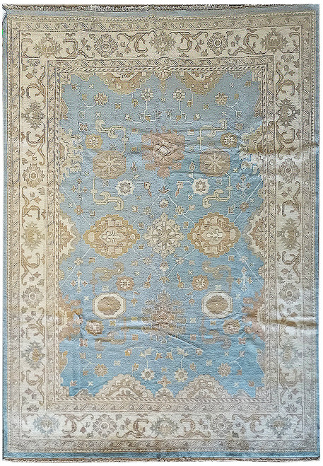 Light blue Oushak rug with ivory border and camel palmettes, full overhead view of wool pile