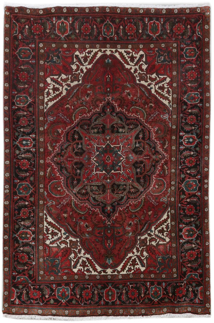 Full overhead view of red Persian Heriz rug with black medallion and ivory corner spandrels