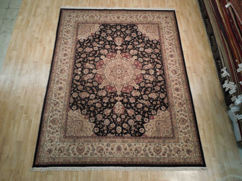 Black field 7'9" x 9'9" Sino Tabriz rug with ivory border on light wood floor