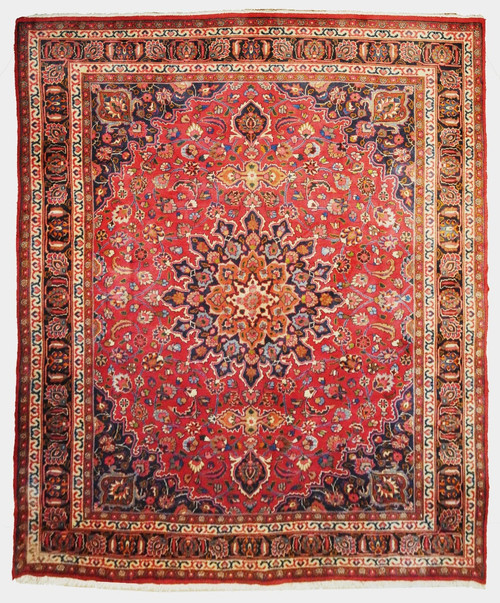 Full view of 9'6" x 12'6" Persian Mashad rug with burgundy field and navy floral medallion
