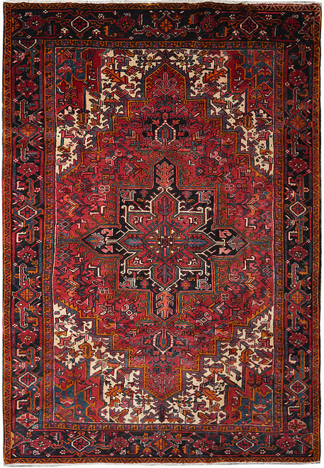 Full overhead view of crimson Persian Heriz rug with black star medallion and ivory corners