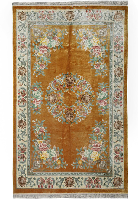 Full overhead view of honey gold Chinese Aubusson silk rug with ivory floral border