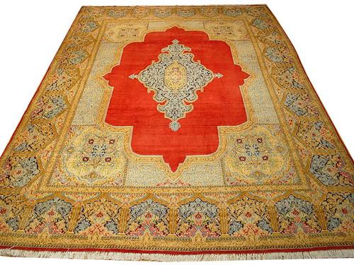 Red Persian Kerman rug on white background with gold floral border and ivory lobed central medallion