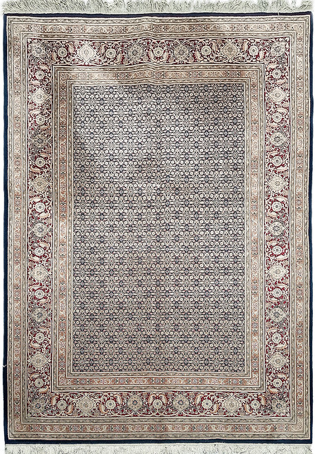 Overhead view of navy Mahi fish pattern wool rug with red floral border and ivory fringe