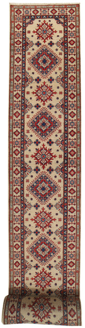 Full length view of 3x26 ivory Kazak runner with alternating red and navy stepped medallions