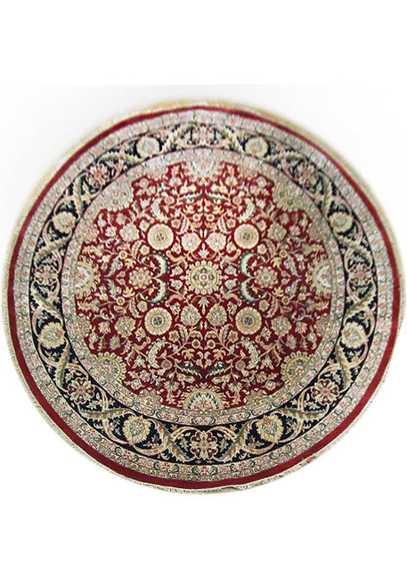 Full overhead view of the round red rug with ivory centre medallion and wide black floral border