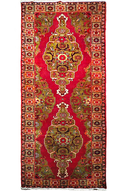 Full overhead view of the long red Heriz rug with two olive medallions and panelled border