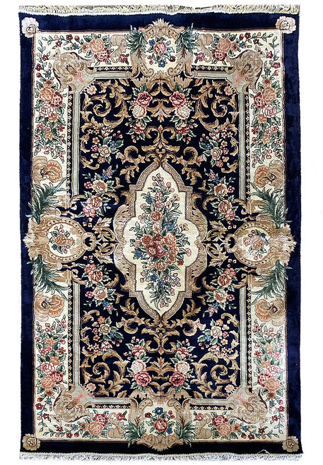 Full overhead view of the navy Aubusson rug with ivory floral medallion and cream border