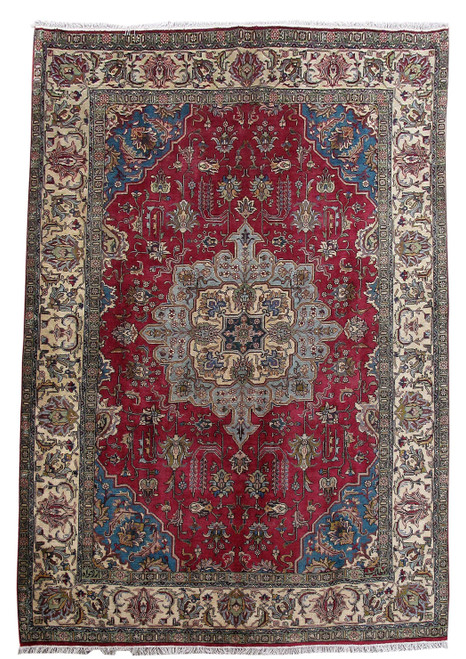 Full overhead view of red Persian Tabriz rug with pale blue medallion and wide ivory floral border