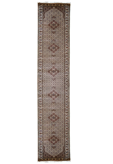 Full length 2'7" x 17'2" ivory Mahi runner rug with repeating brown diamond medallions