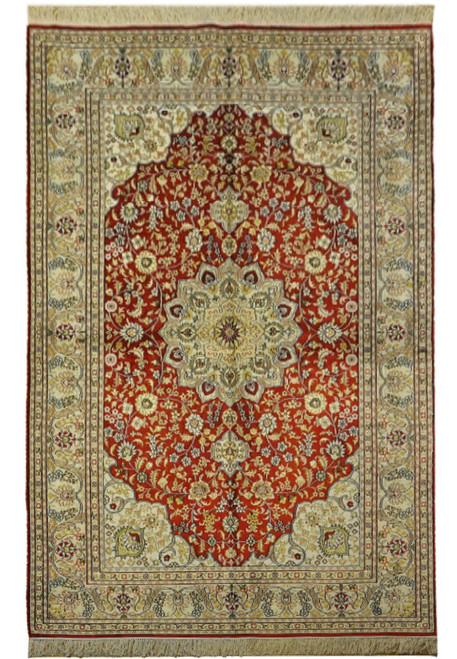 Overhead view of red silk Oriental rug with ivory floral border and gold star medallion