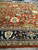 Navy main border with ivory and gold palmettes beside the rust field, close corner detail