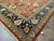 Corner of the 14' x 22'2" rug with ivory fringe, navy border and warm terracotta field