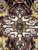 Macro of ivory medallion center showing 8 petal rosette and slate blue square core