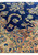 Detailed view of the corner of the Persian Kerman Lavar rug with floral border design