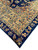 Corner detail showing camel gold main border with blue and rust floral vines, ivory guard stripe