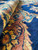 Close-up of thick wool pile along the rust and gold border with deep indigo field