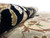 12x18 wool and silk rug rolled to show dense pile and black floral border