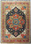 Overhead view of navy blue Serapi rug with coral red star medallion and ivory spandrels