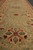 Sage green border detail with 8 petal gold rosettes and burgundy flower heads, hand-knotted wool