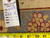 Back tag marked rug number 6487 beside a tape measure on the knotted reverse