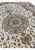 Angled shot of the Tabriz medallion showing layered rings of blush, sage green, and rust palmettes