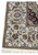 Taupe main border with palmettes and flower clusters on a signed Isfahan rug, navy corner spandrel