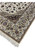 Corner of a wool and silk Persian Isfahan rug with silk fringe, ivory guard borders and taupe main border