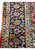 Close view of the navy palmette border and ivory vine guards on a hand-knotted Isfahan rug