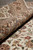 Rug rolled on the floor, silk sheen visible across the border palmettes and ivory ground