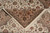 Corner of the rug folded back over itself, showing fringe, selvedge and the border palmettes