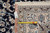 Folded corner with seller tag reading 8x11'7 and a tape measure across the ivory border