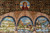 Upper arcade detail: Madonna roundel above three gothic arches showing hills, gorge and castle