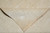 Triangular fold showing the face beside the flatter reverse, fringe along the folded edge