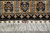Woven signature cartouche on wine red set into the ivory end panel above the fringe
