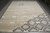 Whole rug on a concrete floor showing the charcoal diamond cluster at the lower right corner
