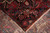 Corner turned back to show the knotted reverse beside the woven face of the border