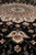 Edge of the medallion with an ivory and rose palmette dropped onto the black field
