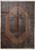 Whole rug seen from above: camel beige field, dark hexagonal medallion, wide blue border, fringed ends