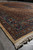 Angled view down one long side, blue main border and cream fringe meeting the floor