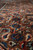 Shallow-focus close up of the brown-toned field with small blue and red Herati flowerheads
