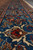 Blue border ground in detail with ivory vine work, red blossoms and a brown cartouche