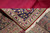 Corner folded back to show the woven reverse beside red pile and ivory fringe